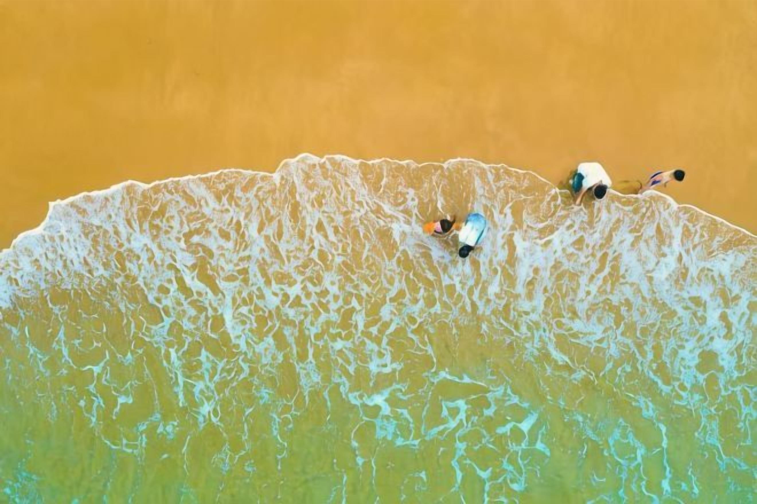Una playa con olas y una persona en el agua.