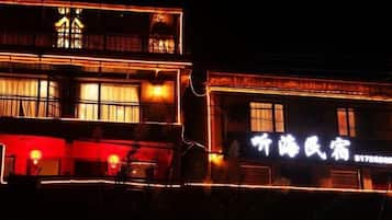 Un edificio con letreros iluminados y un balcón.