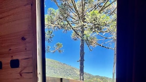 A wooden cabin with a view of a tree and a mountain. - Cabanas Cambuim - Urubici - SC (Urubici)