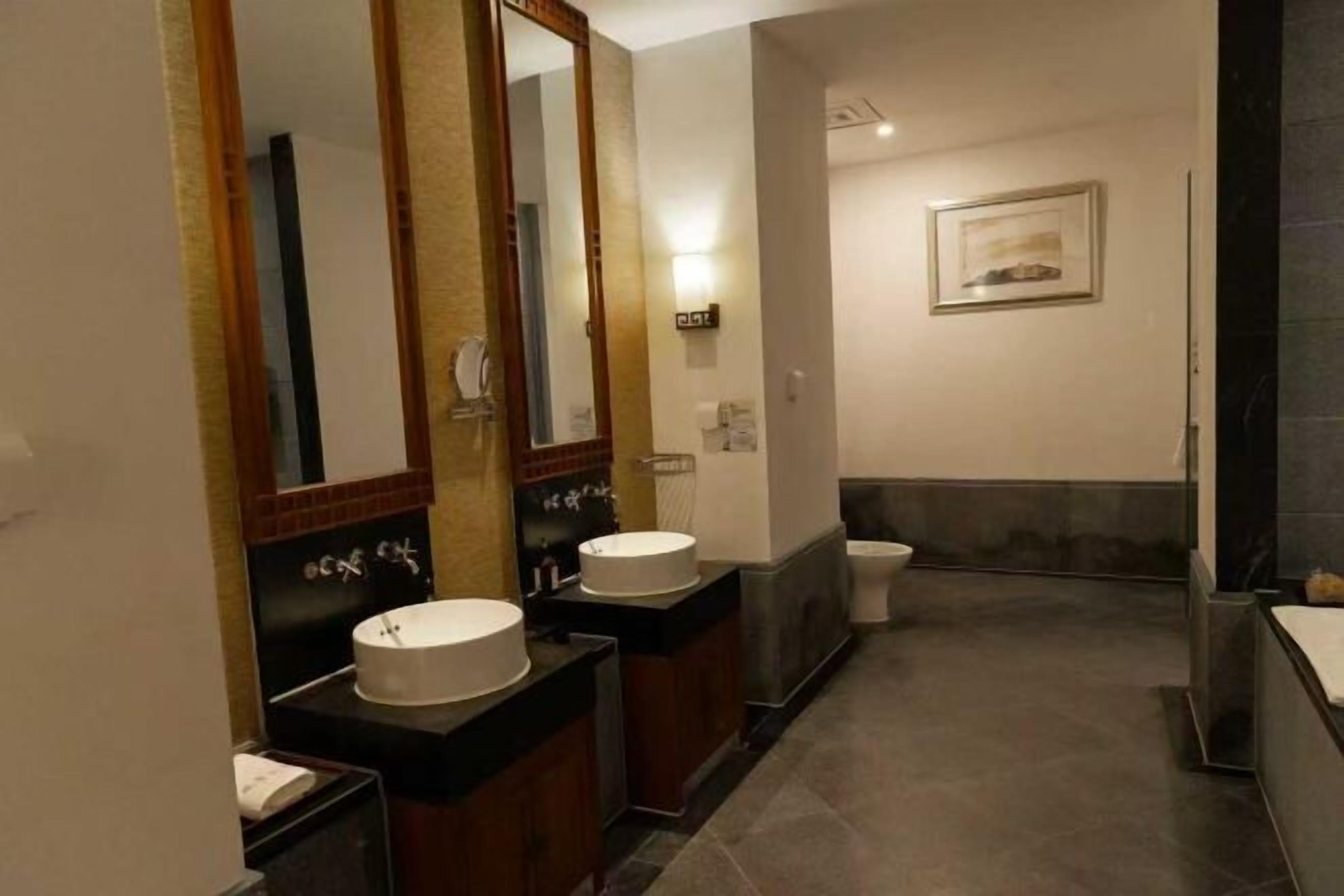 Ein Badezimmer mit zwei Waschbecken, einer Toilette und einem Spiegel.