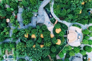 Luftaufnahme eines Parks mit Wegen, Bäumen und einer zentralen, runden Fläche mit Sitzgelegenheiten.
