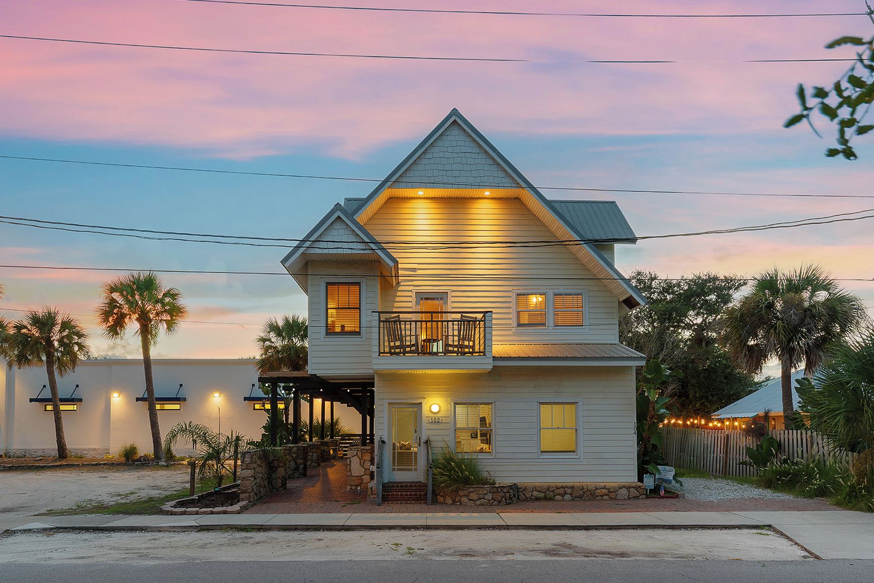 A two-story house with a balcony, a porch, and a small front yard.