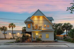 A two-story house with a balcony, a porch, and a small front yard.