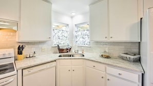 A kitchen with white cabinets, a built-in oven, and a dishwasher. - Longview Vacation Rental Home: 4 Mi to Dtwn (Longview)