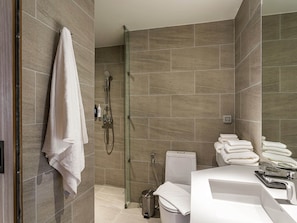 Une salle de bain moderne avec une douche à parois de verre, des toilettes et un lavabo avec un miroir.