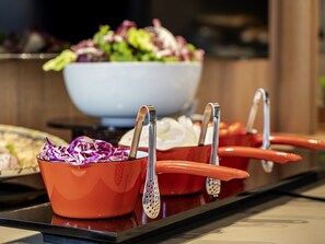 Une table de buffet avec divers plats et ustensiles de service.