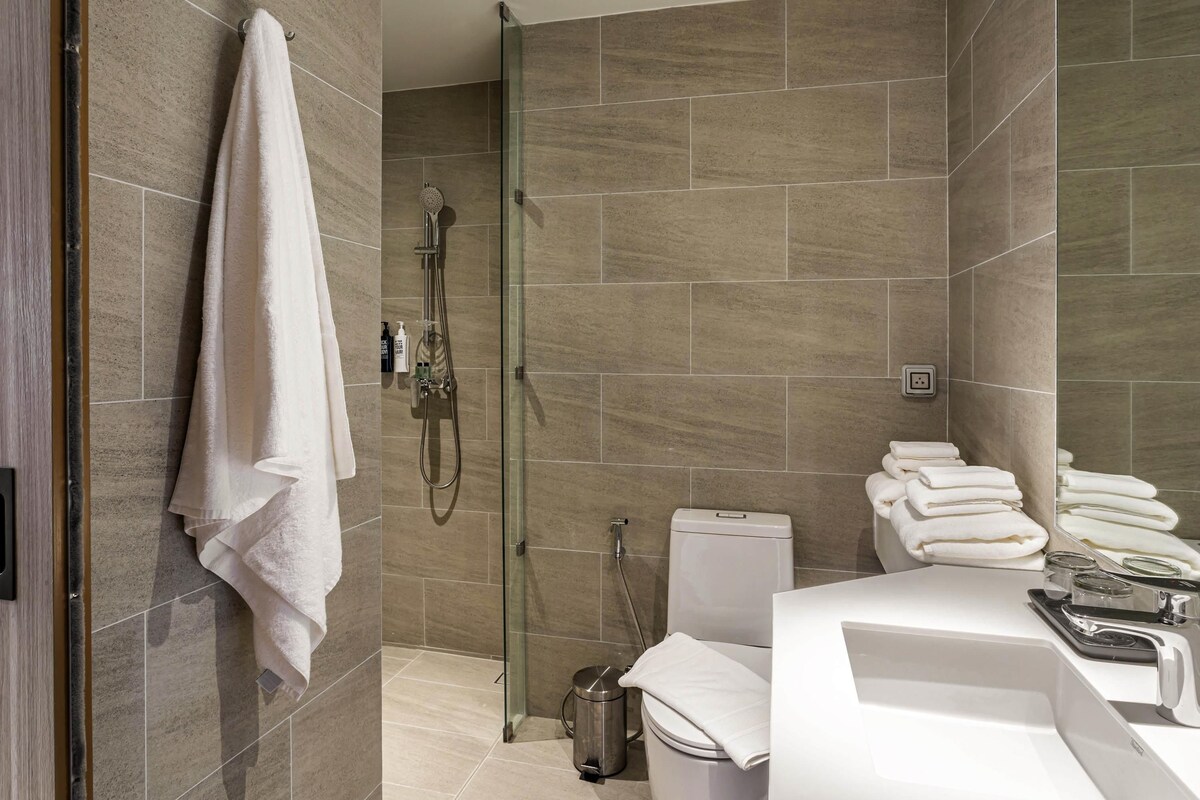 Une salle de bain moderne avec une douche à parois de verre, des toilettes et un lavabo avec un miroir.