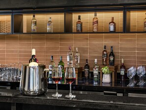 Una zona de bar con una variedad de botellas de licores y vasos.