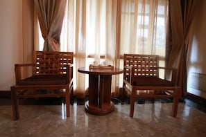 Two wooden chairs with cushioned seats and backs, positioned around a small round table with a matching base. - Yongtai Gening Ant Nest Egg Homestay (Yongtai)