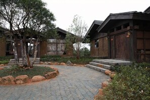 A courtyard with traditional wooden buildings, stone steps, and landscaped greenery. - Yongtai Gening Ant Nest Egg Homestay (Yongtai)