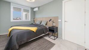 Quarto moderno com cama, abajur e janela com persianas.