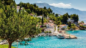 A coastal town with a marina, boats, and buildings with red roofs. - Apartment in Lokva Rogoznica with Seaview, Balcony, Air condition, WIFI (5118-3) (Lokva Rogoznica)