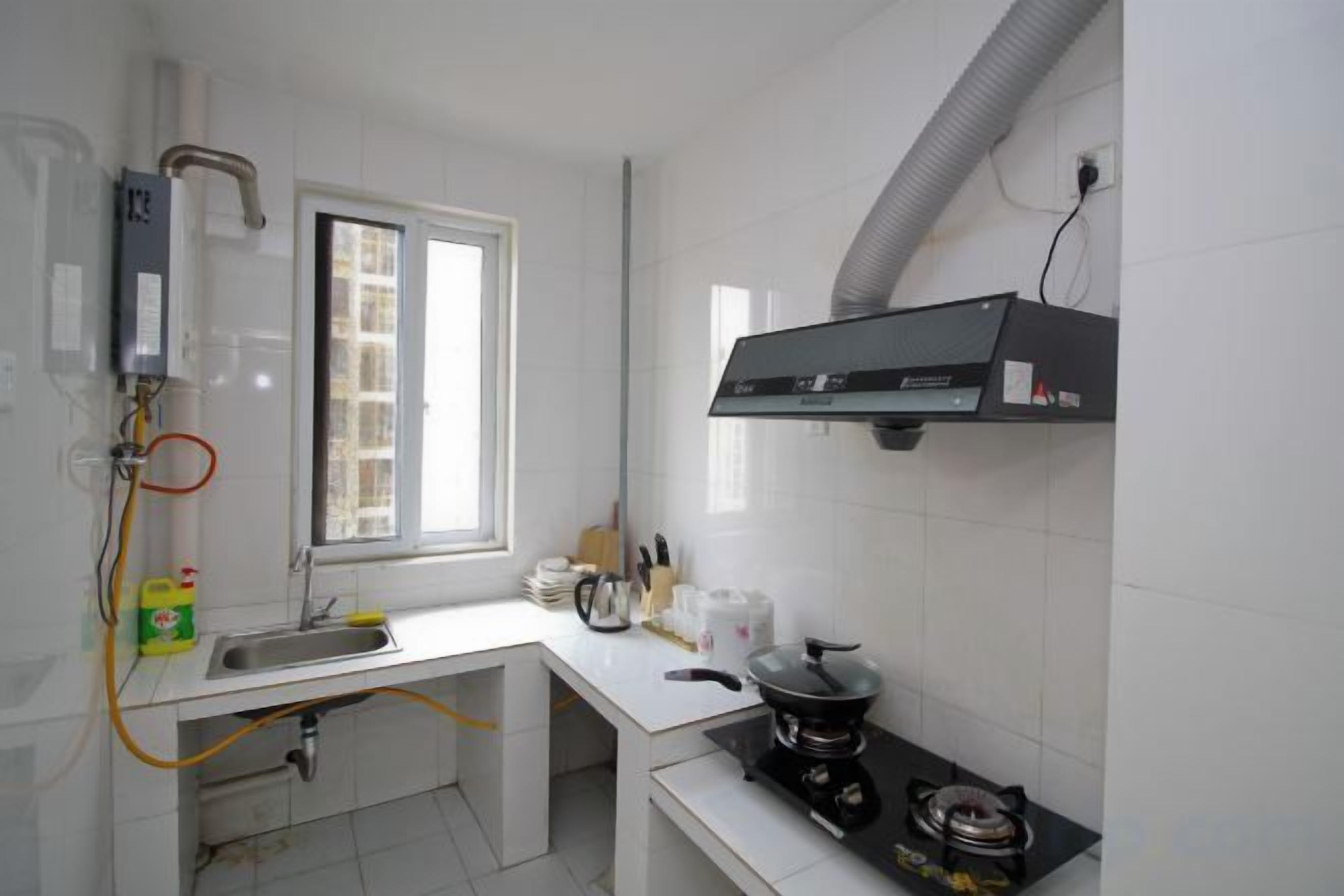 Una cocina compacta con ventana, estufa a gas y lavamanos.