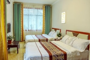 A hotel room with two beds, a TV, a desk, and a window with curtains. - Yigen Zhijia Inn (Fenghuang County)