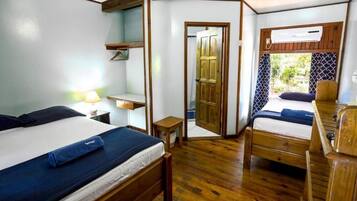 Una habitación pequeña con dos camas de madera, una mesita y una silla.