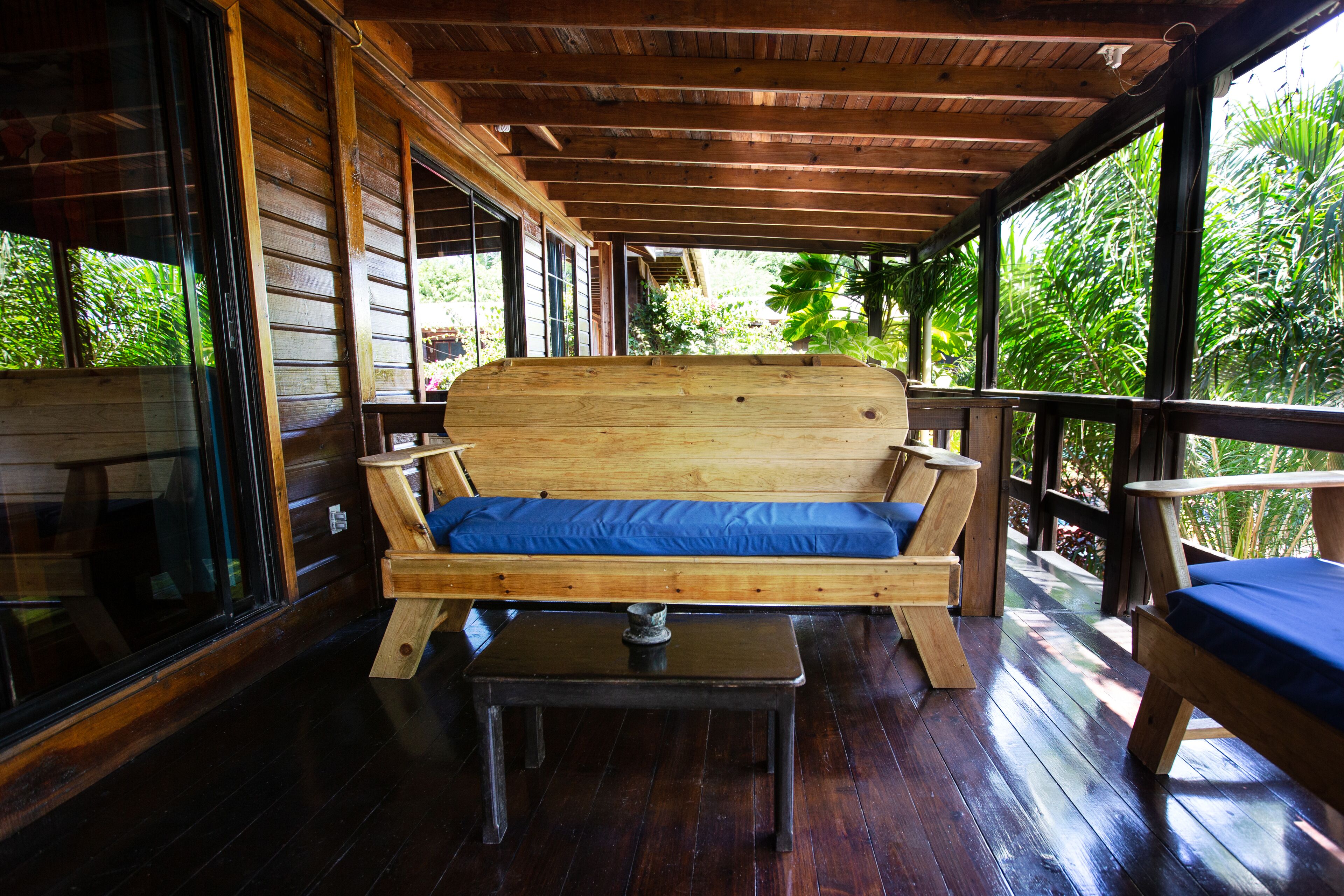 A wooden deck with a wooden bench and a table.