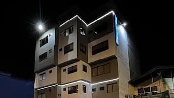 Vista frontal de la propiedad por la tarde o noche