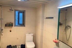 A bathroom with a toilet, a shower, and a window. - Chongqing Ruika Apartment (Guanyinqiao Pedestrian Street) (Chongqing)