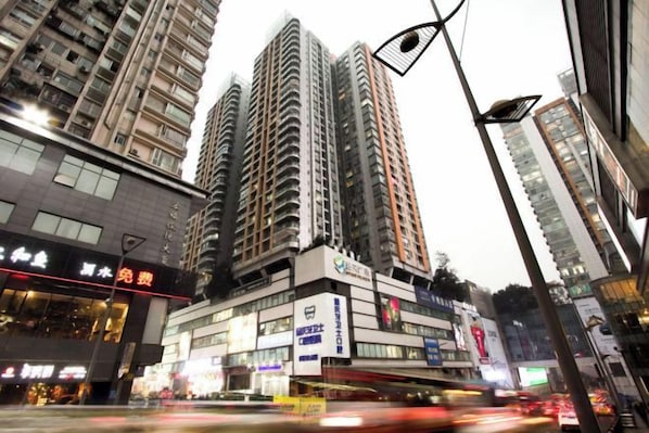 A city street with tall buildings, a bus stop, and a pedestrian crossing.