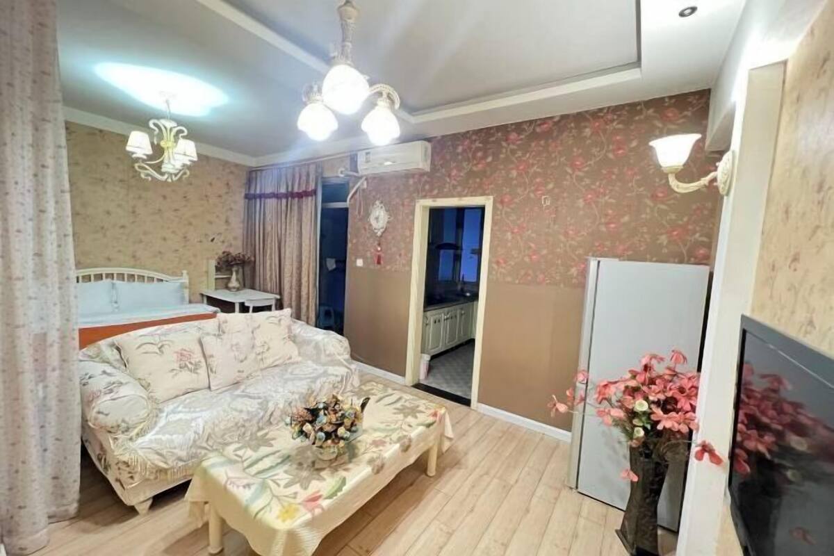 Ein Wohnzimmer mit Sofa, Couchtisch, Fernseher und einer Zierdevasse.