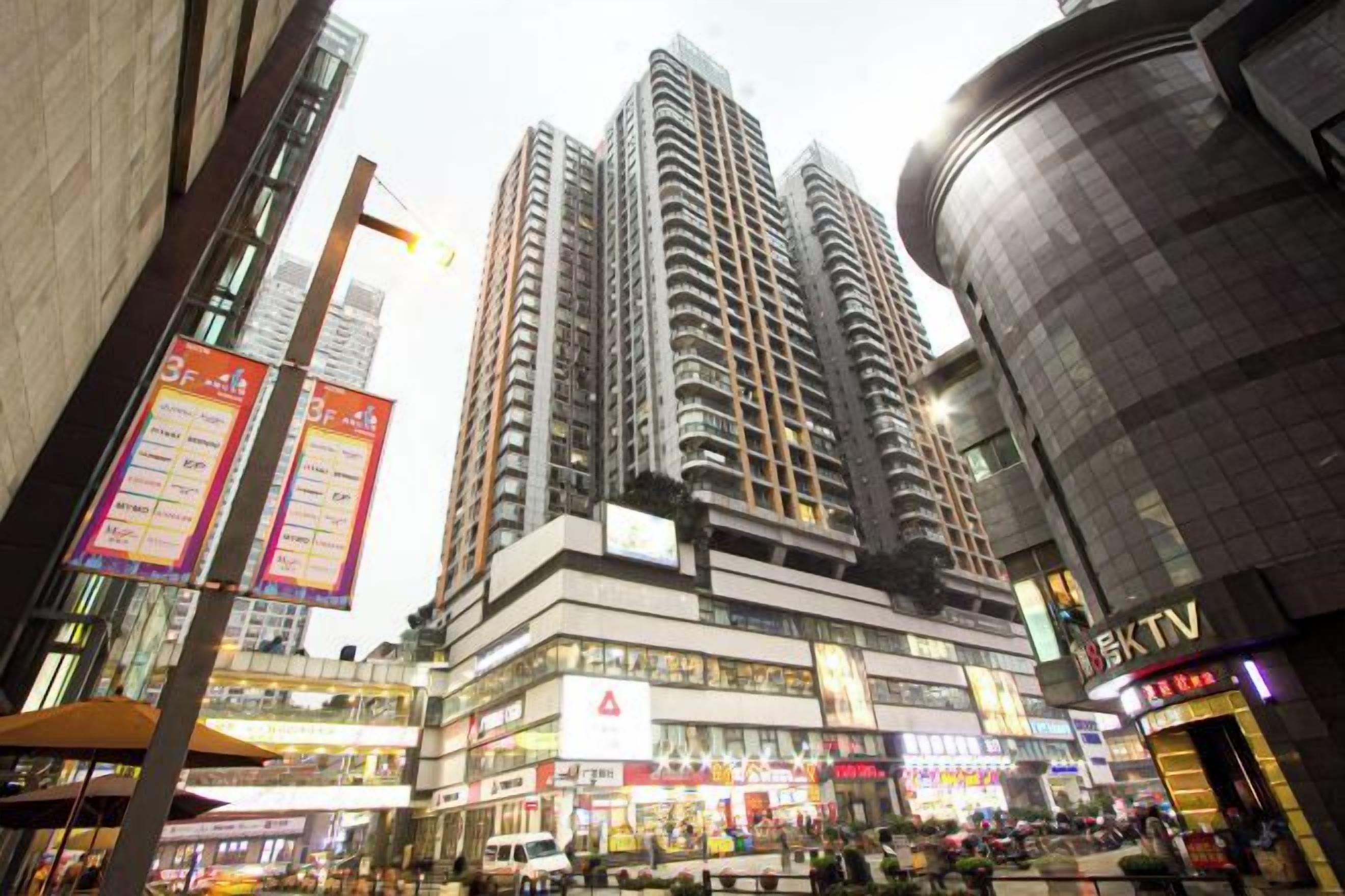 A high-rise building with multiple floors, a commercial area with shops, and a KTV sign.