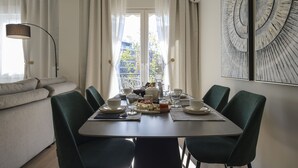 Un'area dedicata alla colazione, con un tavolo apparecchiato, piatti, tazze e un vassoio di frutta.