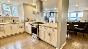 A modern kitchen with white cabinetry, stainless steel appliances, and a large island. - Amazing View of Commencement Bay in Old Town Tacoma (Tacoma)