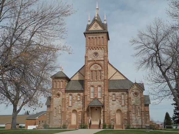 Una iglesia grande de ladrillo con una torre destacada y ventanas arqueadas.