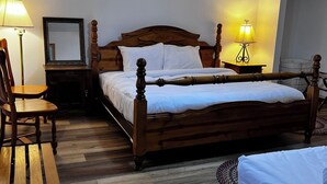 Un dormitorio con dos camas, suelo de madera, ventilador de techo y lámparas de noche.