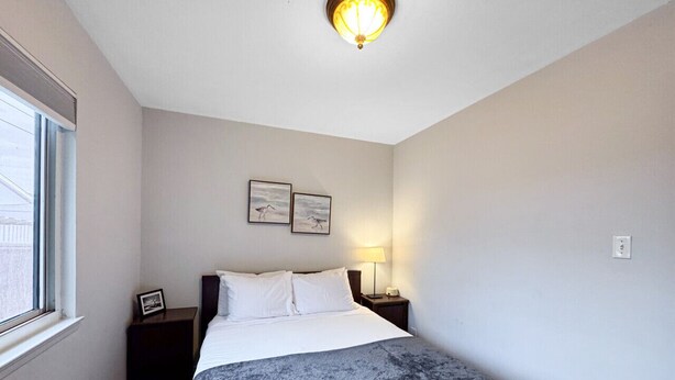 A bedroom with a bed, nightstands, a lamp, and wall art. - Quaint, cute two bedroom home (Mountain View)