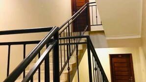Una escalera con barandillas negras que lleva a un piso superior.