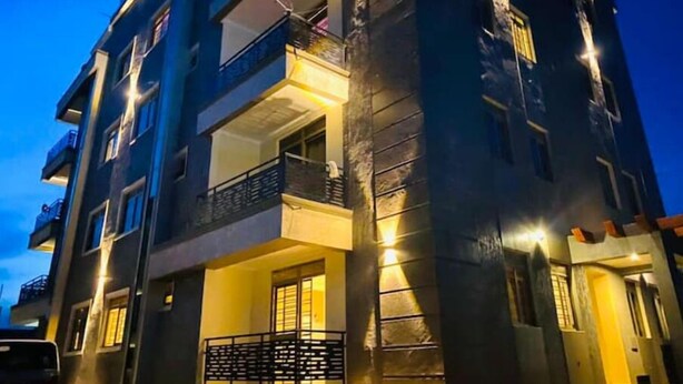 Un edificio de varios pisos con balcones y ventanas iluminadas en la noche.
