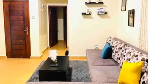 Una sala de estar con un sofá, una mesa de centro y una puerta.