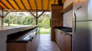 Eine moderne Küche mit Holzschränken, einem Edelstahlkühlschrank und einem eingebauten Herd.