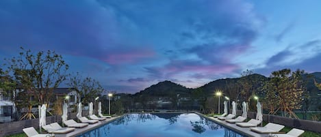 Alberca al aire libre y camastros