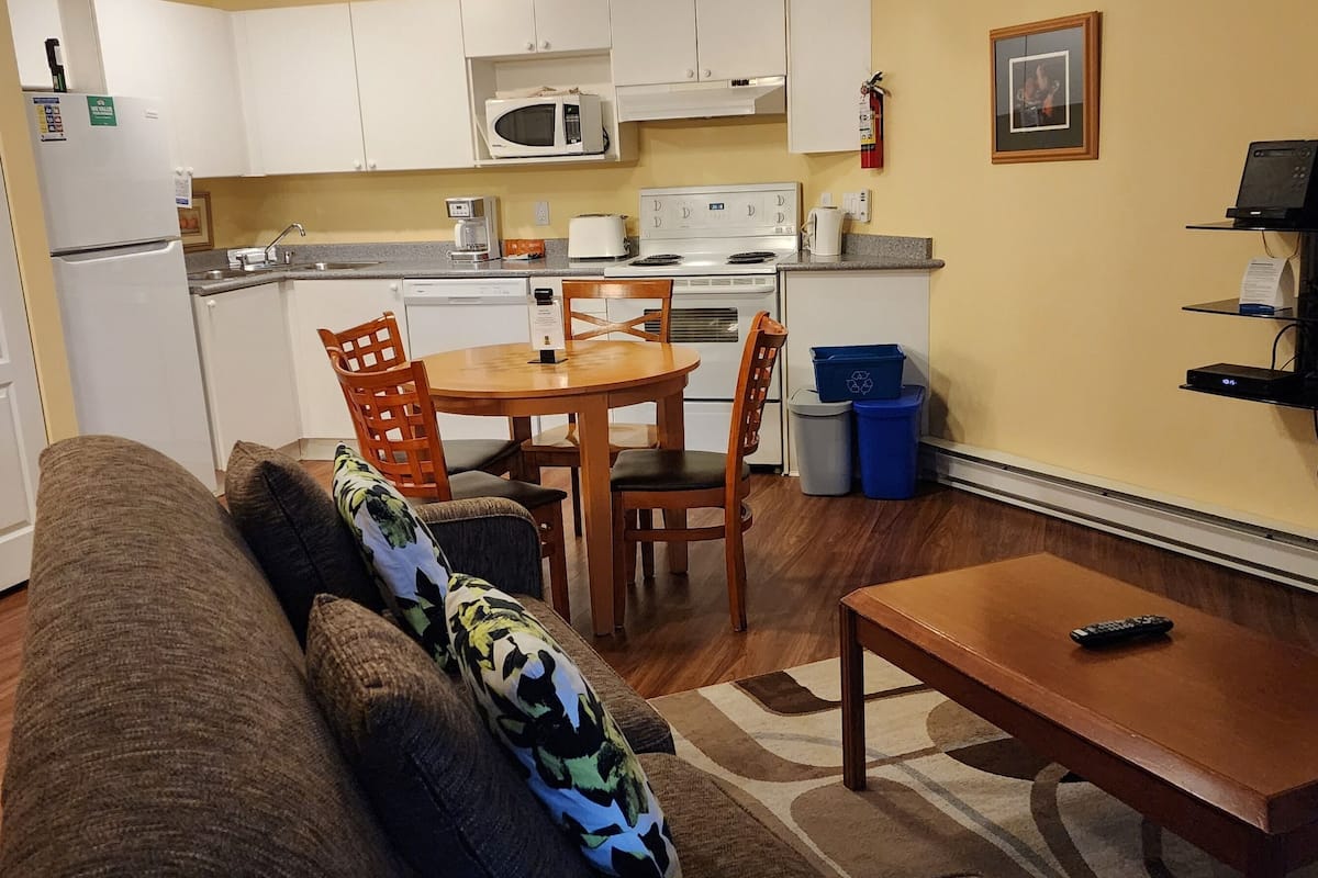 A compact living space with a kitchenette, a dining area, and a seating area.