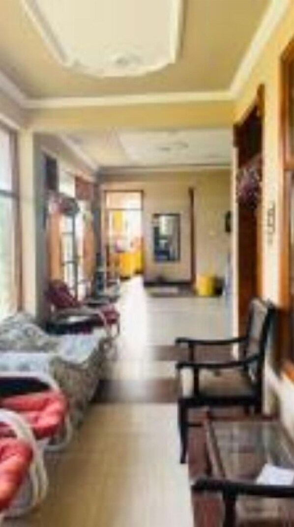 Relax in our spacious lobby, featuring comfortable seating areas and a high ceiling with decorative accents.