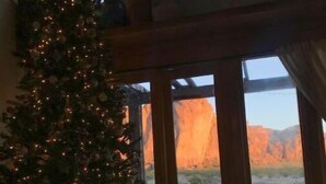 A Christmas tree in a room with large windows overlooking a rocky landscape. - Casa Buena Vista at Hueco Tanks (El Paso)