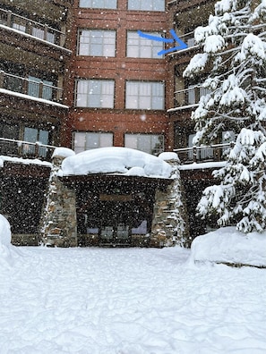 A multi-story building with a stone entrance and snow-covered surroundings. - ⭐ GUEST FAVORITE — BOOK ASAP! ⭐ (Truckee)