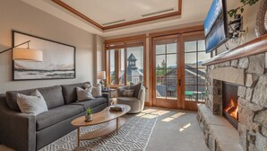 A cozy living room with a stone fireplace, a large window with a view of a tower, and a comfortable sofa set. - ⭐ GUEST FAVORITE — BOOK ASAP! ⭐ (Truckee)