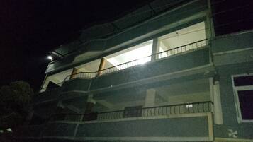 A multi-story building with balconies and a visible window on the second floor.