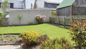 A garden with a variety of plants and a wooden fence. - 3 bedroom accommodation in Portknockie (Portknockie)