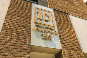 Une enseigne indiquant « TD Home & Lifestyle Jauaperi 299 » sur un bâtiment en briques.