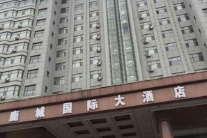 A multi-story building with a sign indicating it is a hotel. - Lucheng International Hotel (Xifeng)