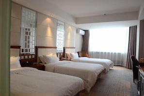 A hotel room with two beds, a desk, and a large window with curtains. - Lucheng International Hotel (Xifeng)