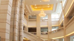Un intérieur à plusieurs niveaux, agrémenté d’un magnifique escalier, de lustres et d’une architecture classique.