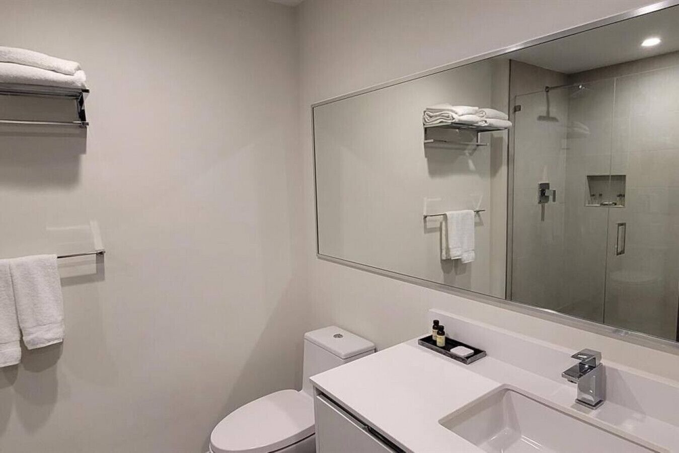 Un baño moderno con inodoro, lavamanos y ducha.