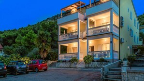 A multi-story building with balconies and a stone staircase leading to the entrance. - Apartments Gulin - One Bedroom Apartment with Terrace and Sea View (Šibenik)