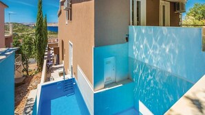 A modern building with a blue pool, a door, and a window. - Apartments Villa Kim - Double Room with Terrace (Jablanac)