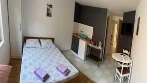 Ein Schlafzimmer mit einem Bett, einem Schreibtisch, einem Stuhl und einem kleinen Tisch.